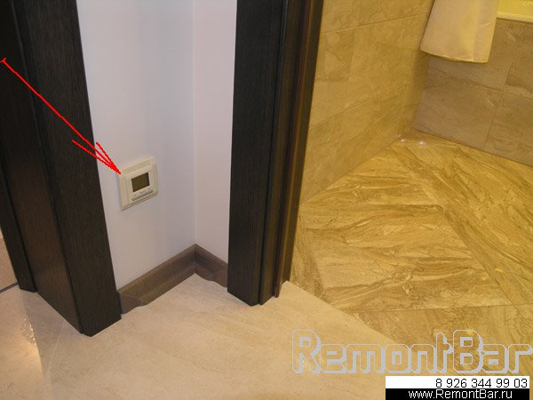 Терморегулятор теплого пола ванной комнаты расположен, как и положено, в коридоре возле двери